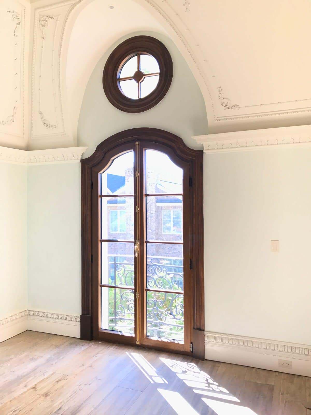 Portes-fenêtres cintrées en acajou à petits bois et œil-de-bœuf rond au-dessus, intérieur de château