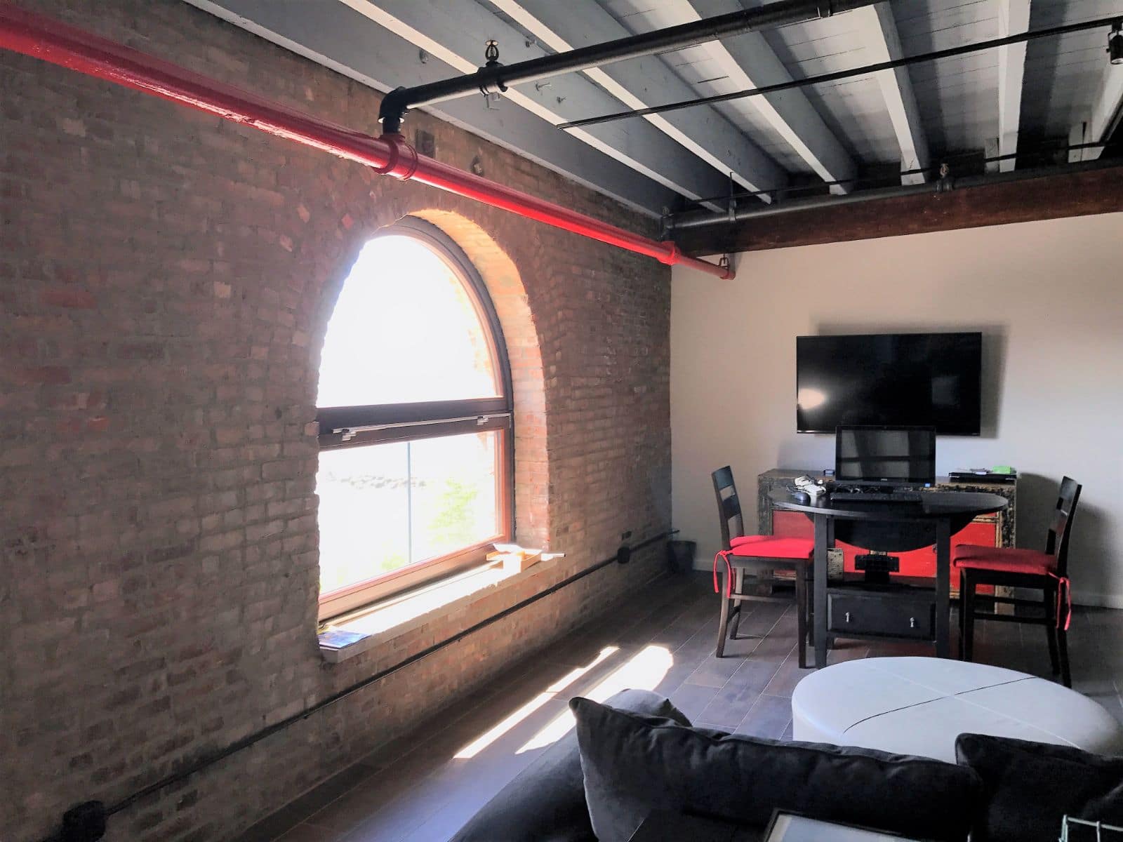 Fenêtre cintrée en bois ajustée à une ancienne arche maçonnée dans un loft à Brooklyn