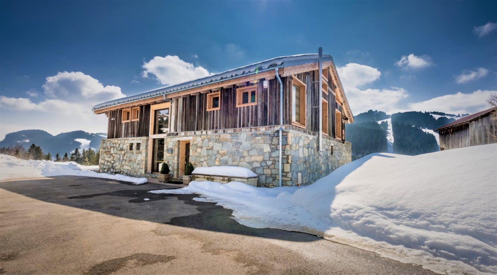 Maison de montagne sous la neige avec fenêtres et portes en bois à triple vitrage