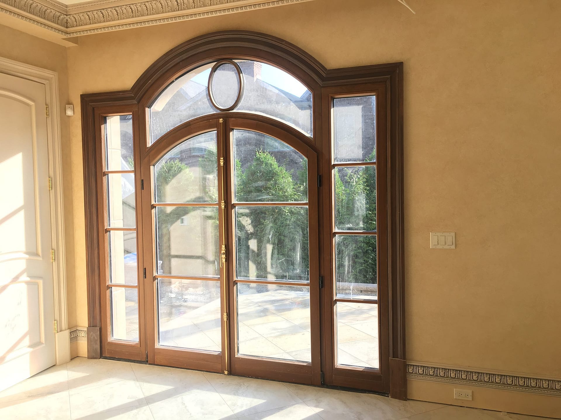 Arched wood French door with a divided-lite transom in a French chateau style residence