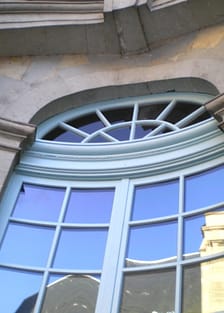 Arched mahogany French door with true divided lites Arched mahogany French door with true divided lites in a stone facade