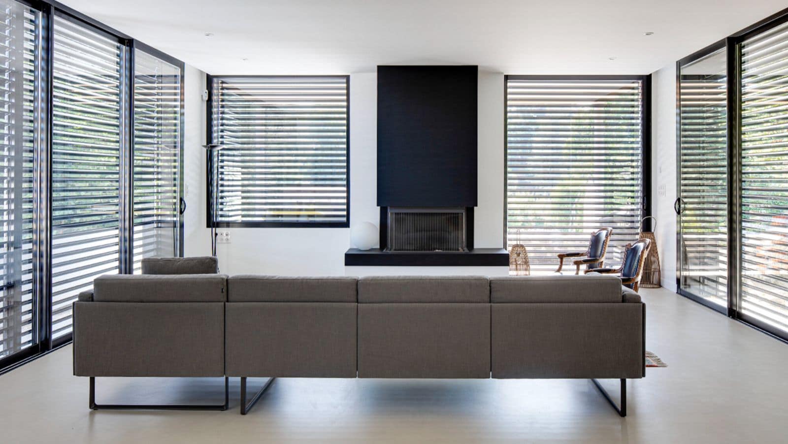 Séjour avec brise-soleil orientables à demi fermés, lumière douce à l’intérieur